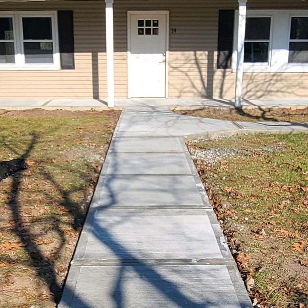 A concrete walkway leading to the front door of a house
