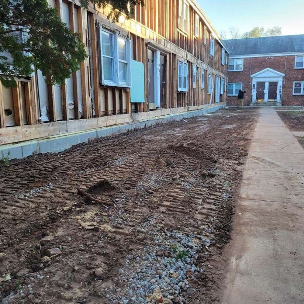 A building under construction with a dirt path leading to it