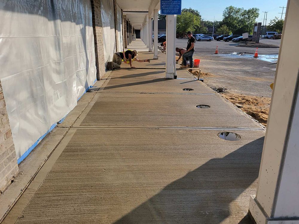 A concrete walkway is being built in front of a building.