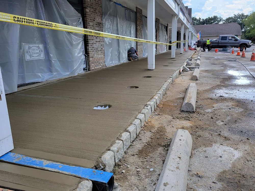 A concrete walkway is being built in front of a building.