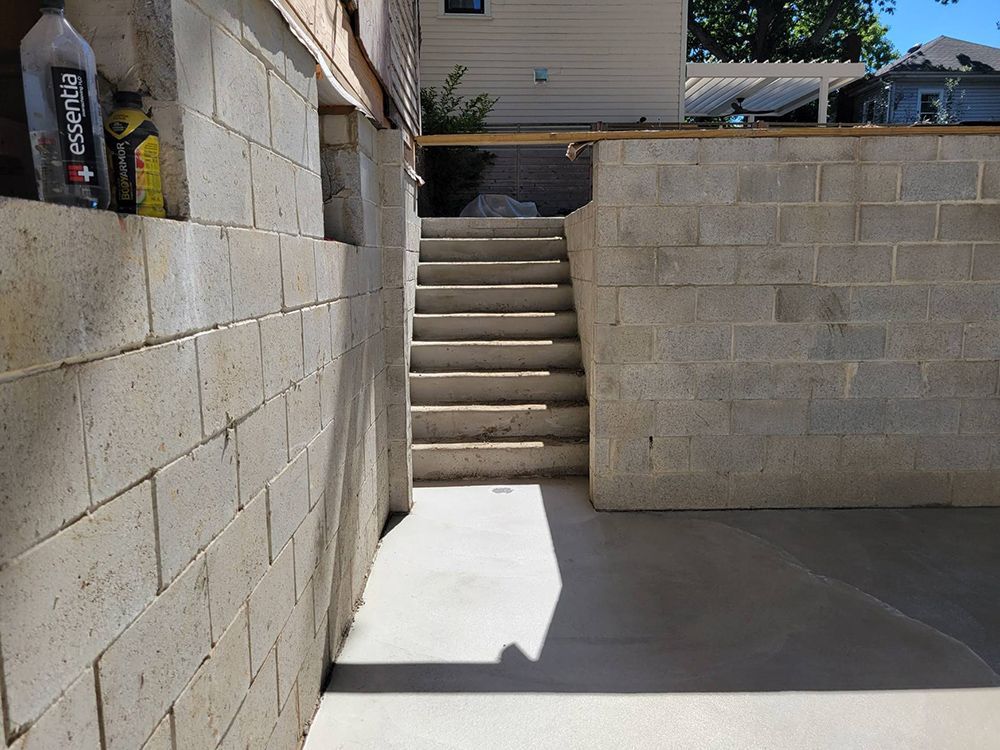 A brick wall with stairs leading up to a house.