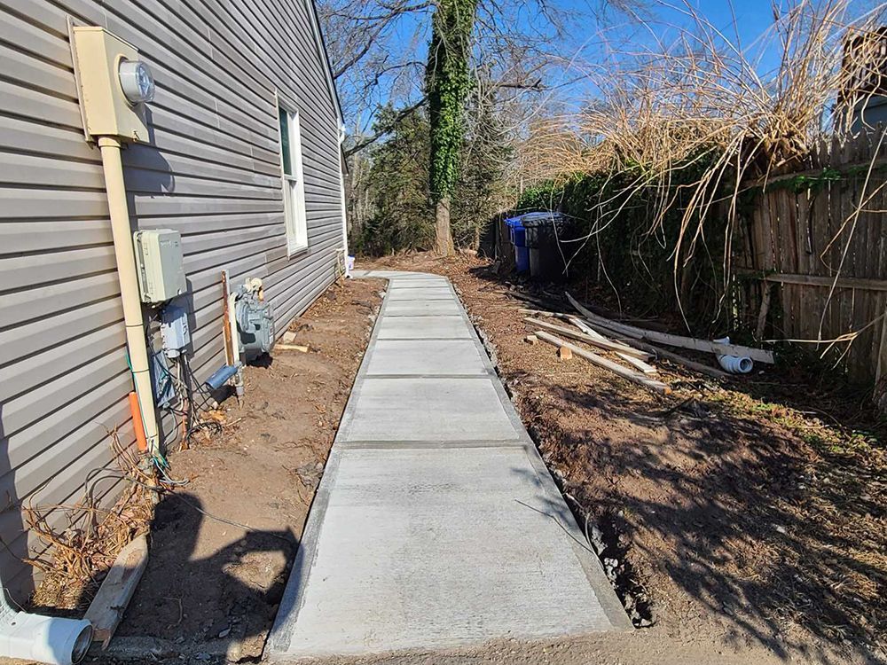 A concrete walkway is being built in front of a house.
