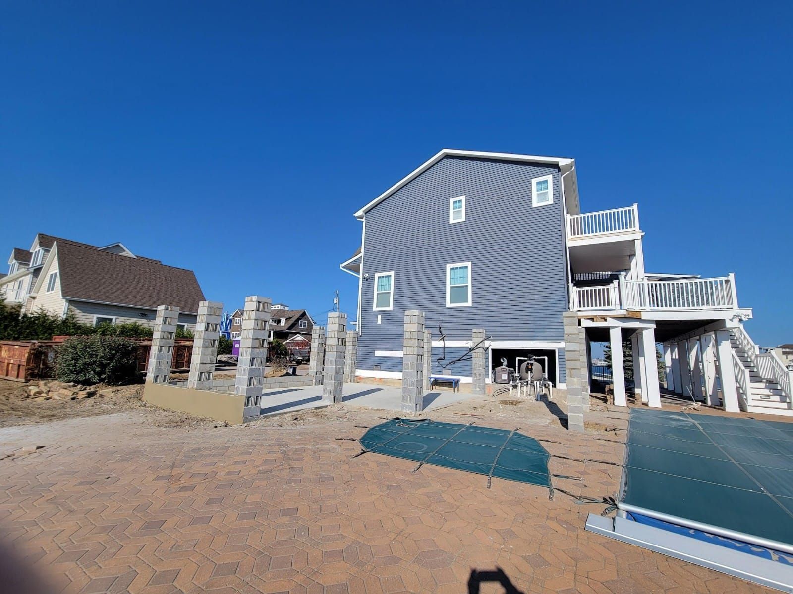 A house is being built on the beach next to a body of water.