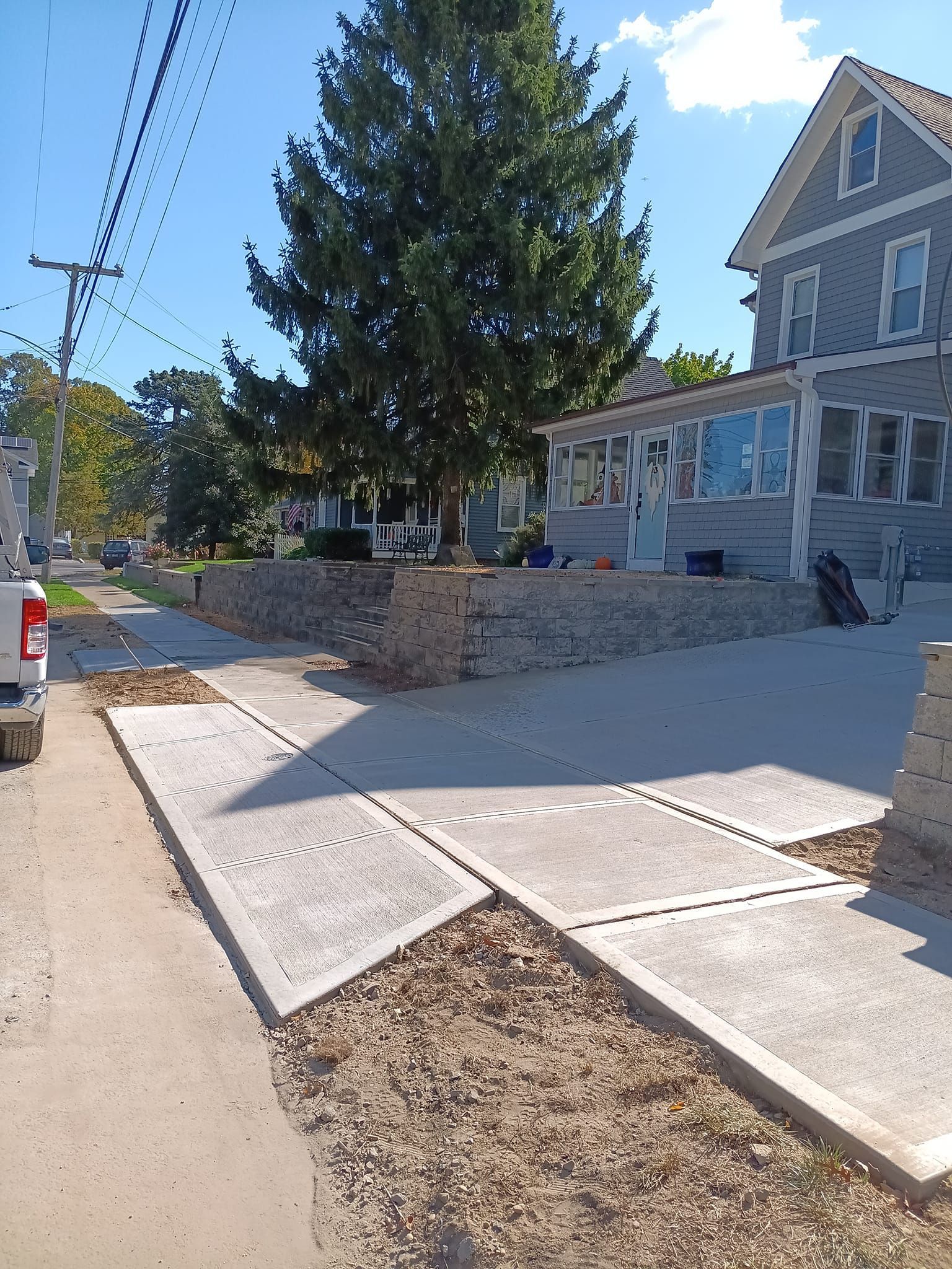 A truck is parked on the side of the road in front of a house.