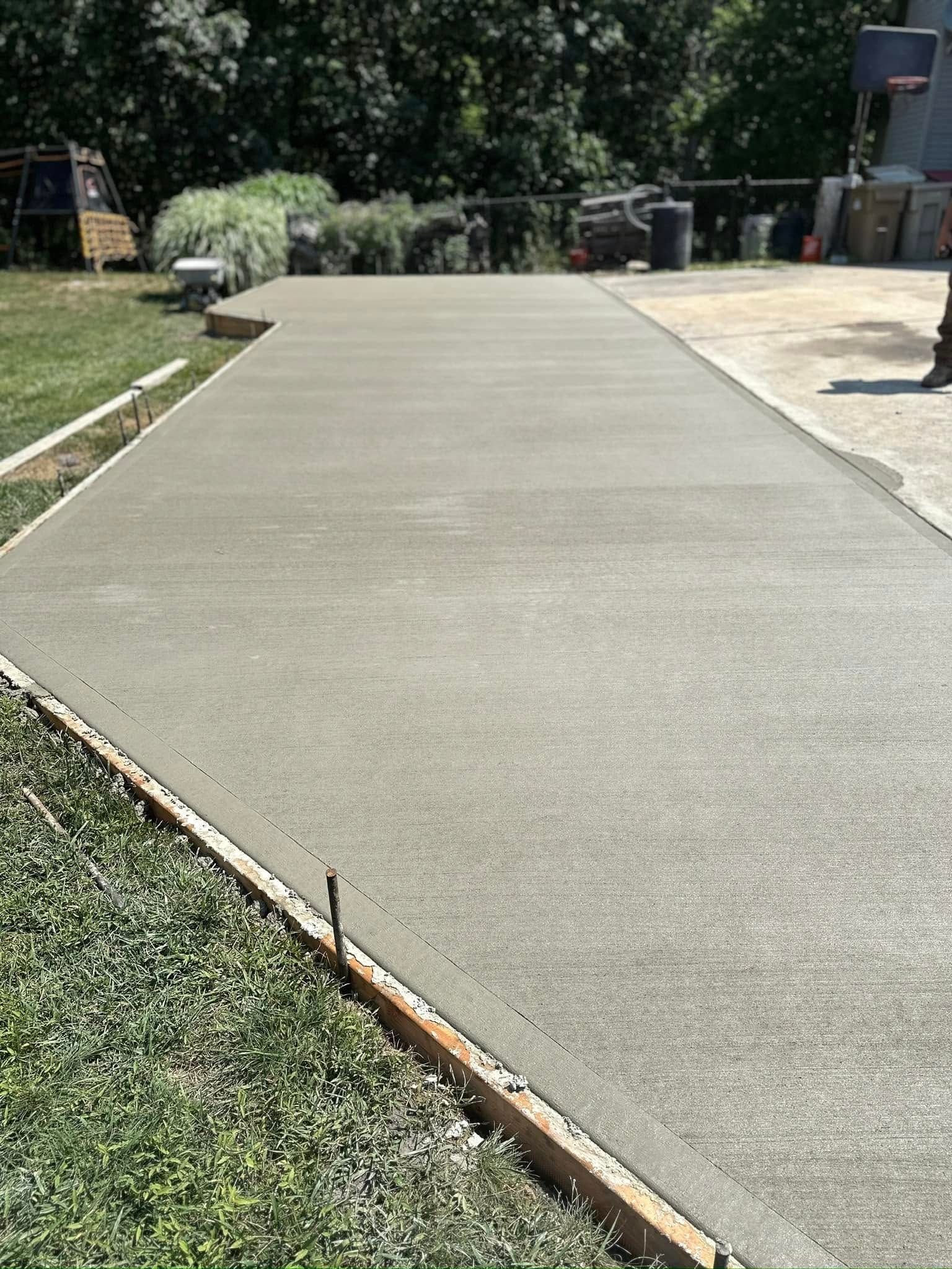 A concrete driveway is being built in a backyard.