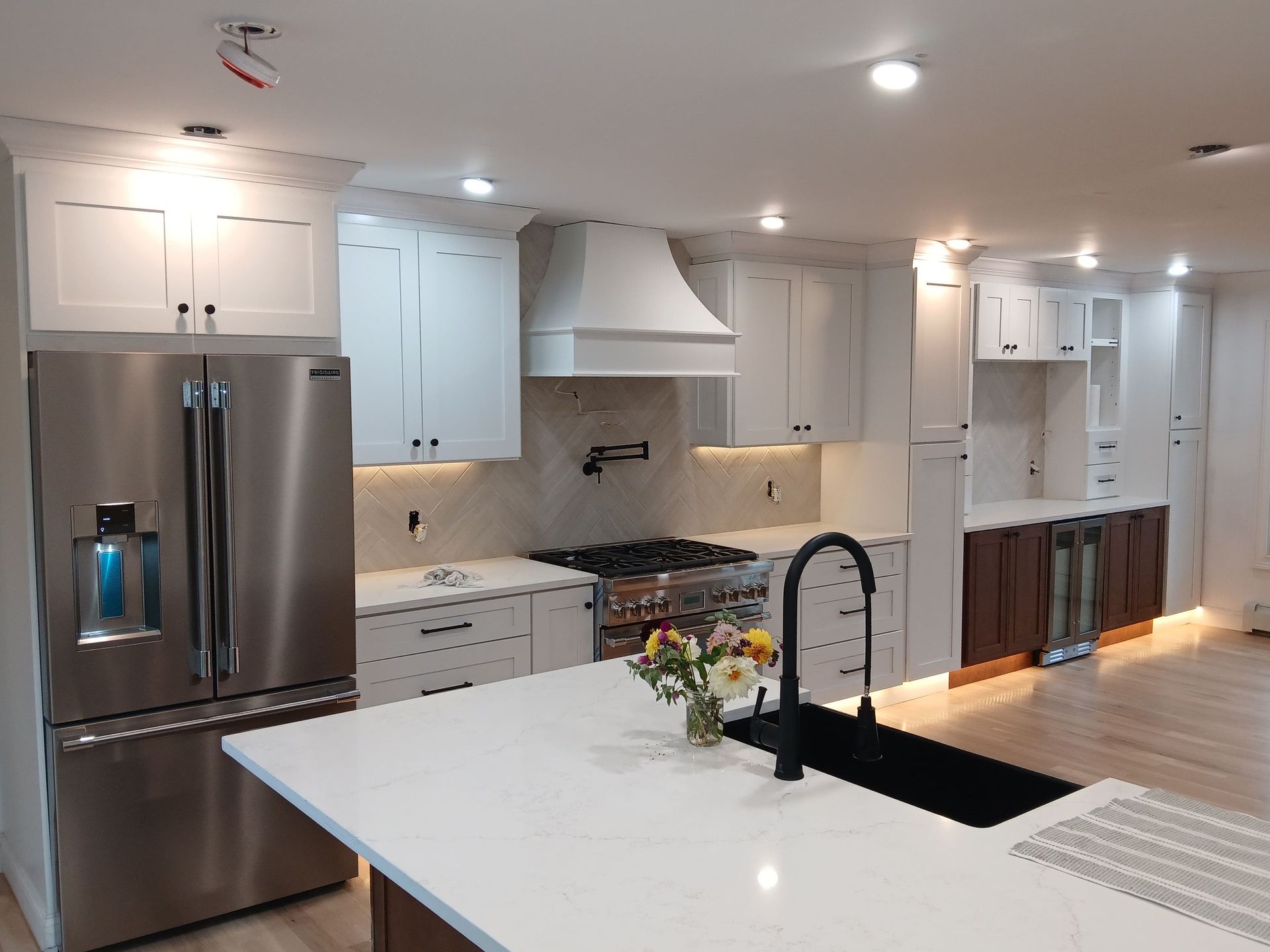 Modern kitchen with white cabinets, stainless steel appliances, and a central island.