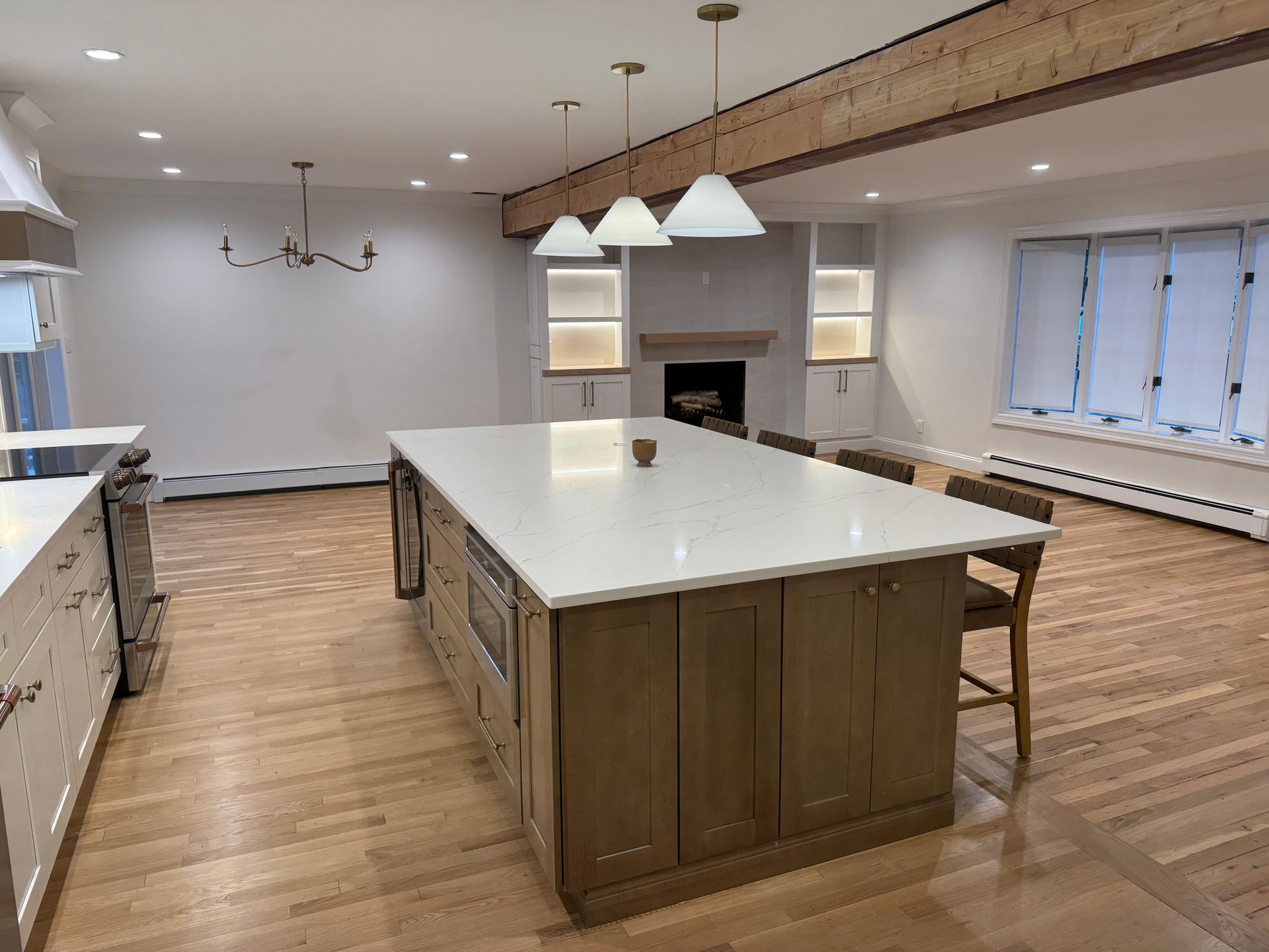 Spacious kitchen with large island, light cabinets, and hardwood floors.