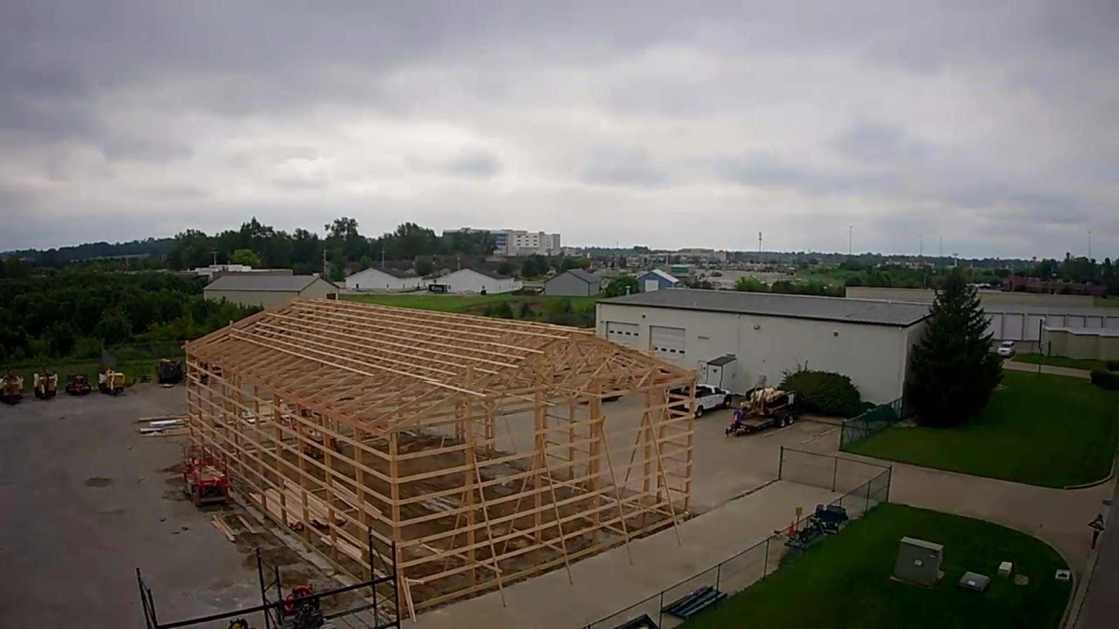 Construction site with wooden framework of a building under a cloudy sky.