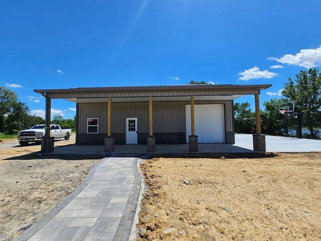 A tan and brown building with a driveway and walkway under a bright blue sky.