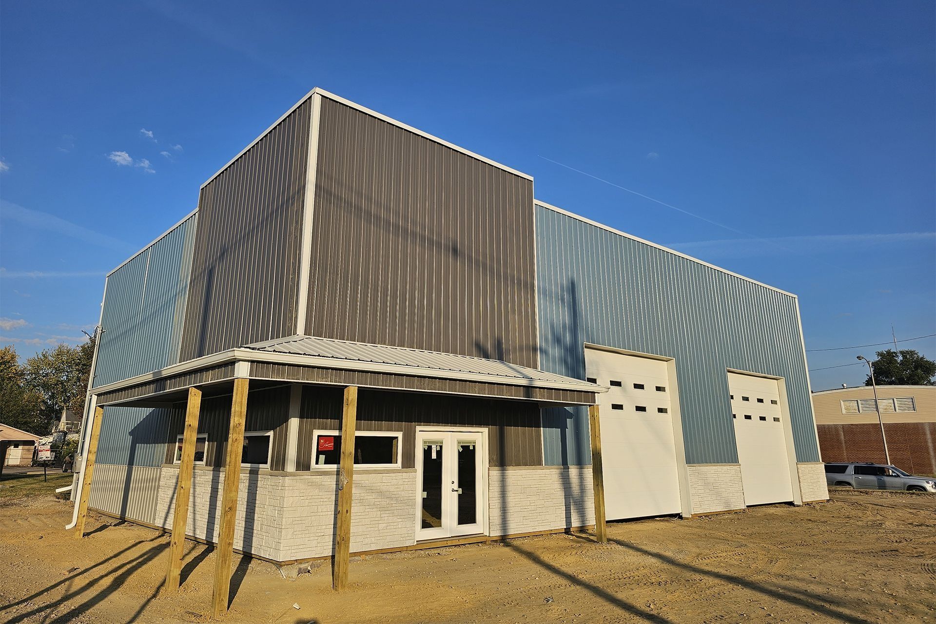 A modern industrial building with corrugated metal siding and a small, covered entrance.
