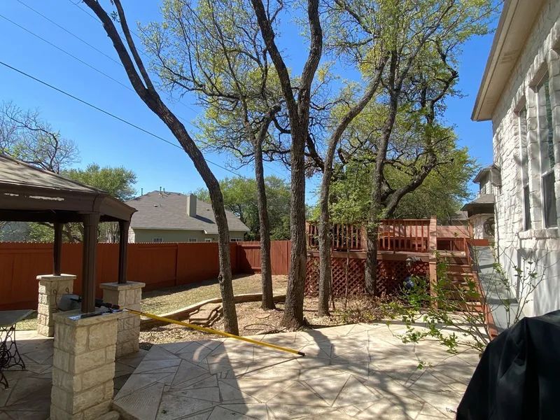 A backyard with trees and a gazebo in the background