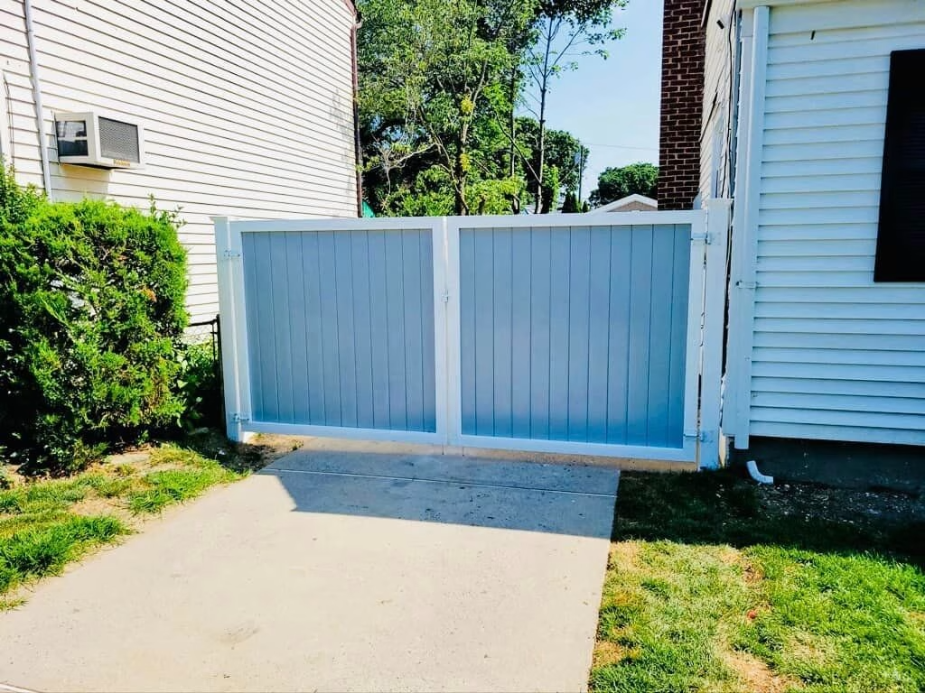 Blue and white wooden fence, between two buildings.