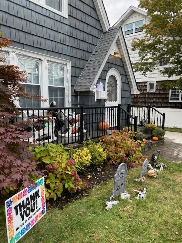 House decorated for Halloween with tombstones, pumpkins, and a 