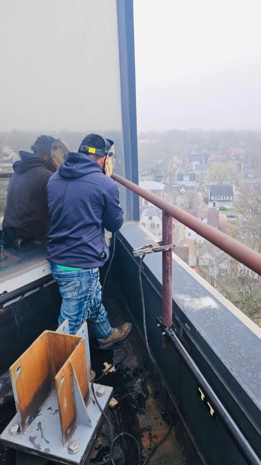 Person uses measuring device on a building rooftop overlooking a cityscape.