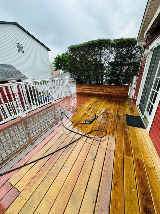 Backyard with wooden playset, blue slide, bare trees, a new white fence, and old wooden fence