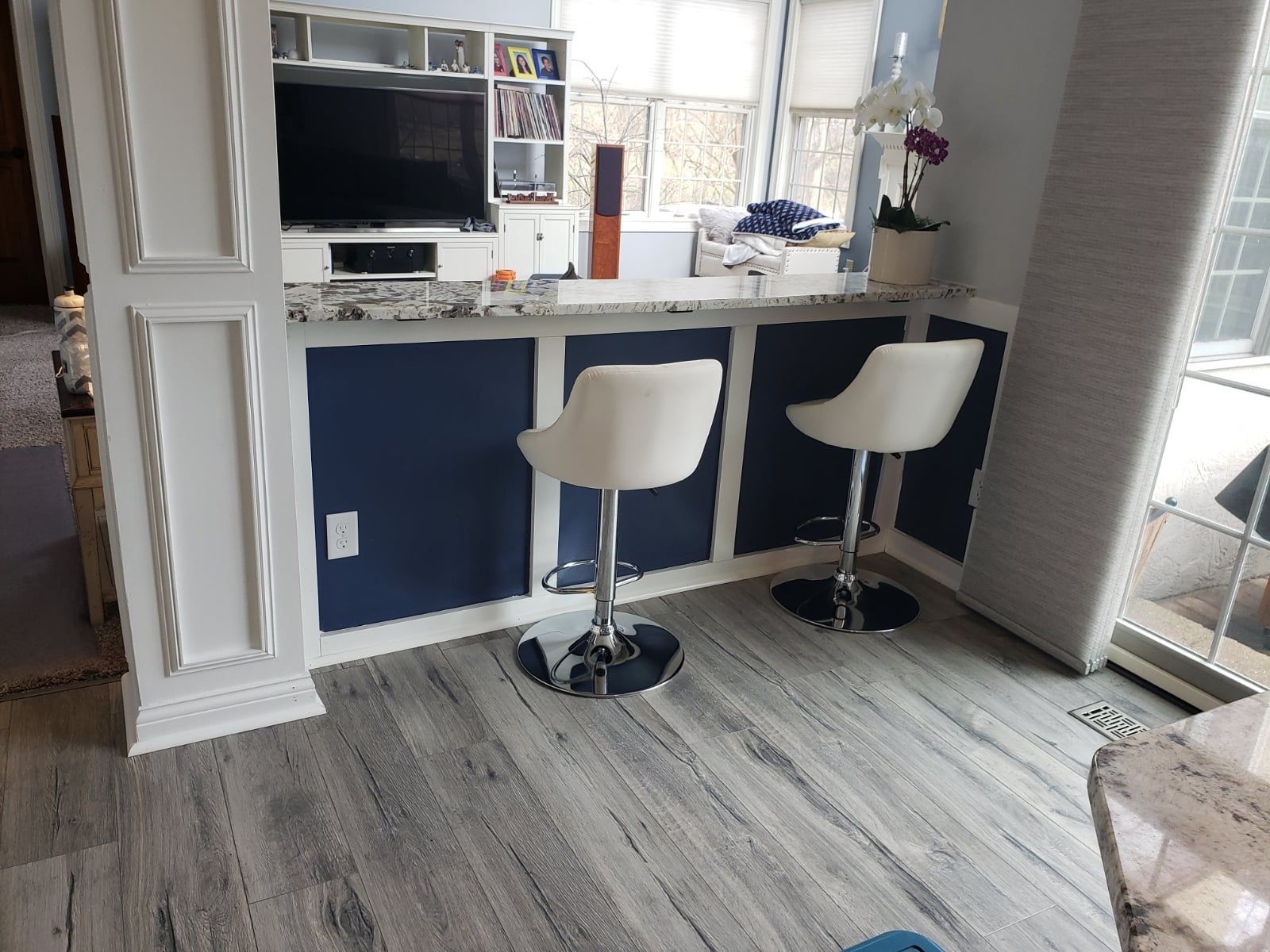 A living room with two bar stools and a television.