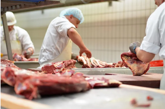 Meat packing plant workers cutting meat in Ottumwa, Ia.