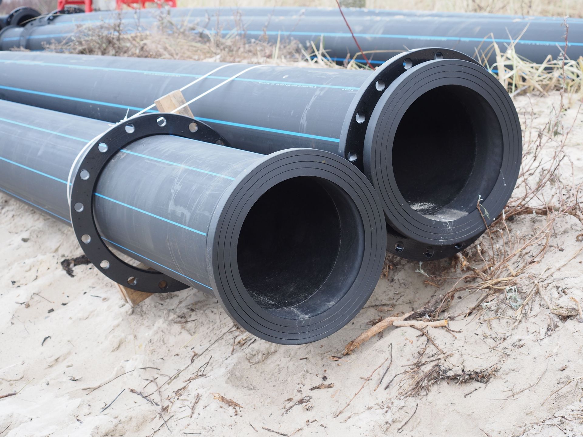 Three white Perron Plumbing vans parked in a cracked lot.