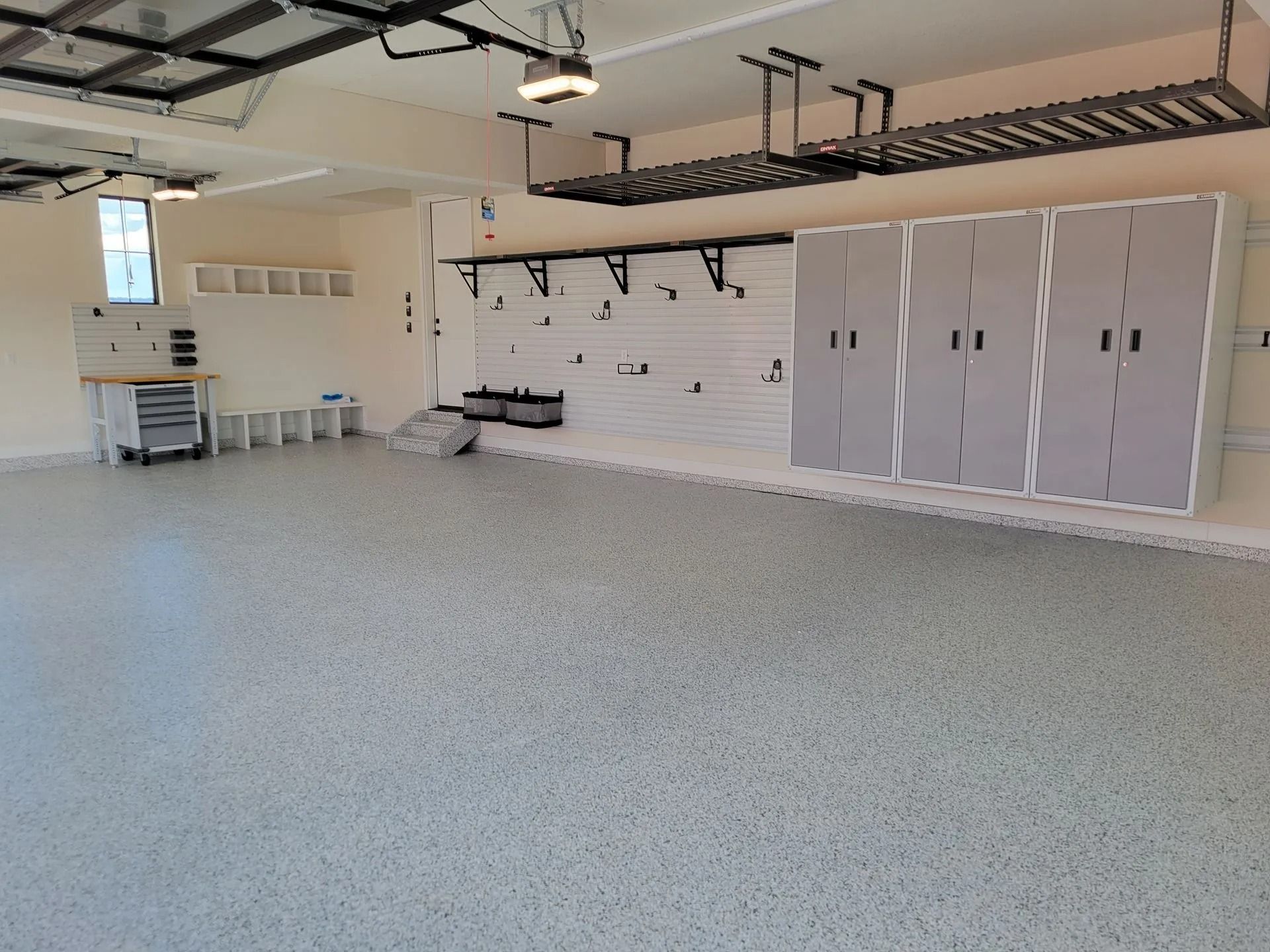 Spacious, organized garage with epoxy floor, storage cabinets, and overhead racks.