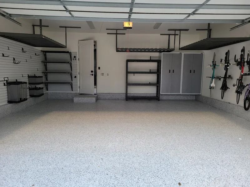 Clean, organized garage with epoxy floor and storage cabinets, shelves, and bike racks.