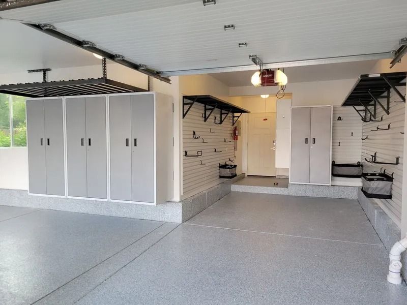 Clean, organized garage with gray cabinets, epoxy floor, and wall storage.