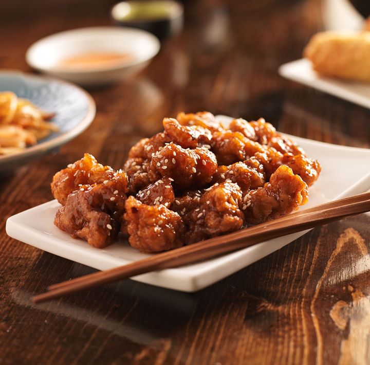 A plate of food with chopsticks on a wooden table.