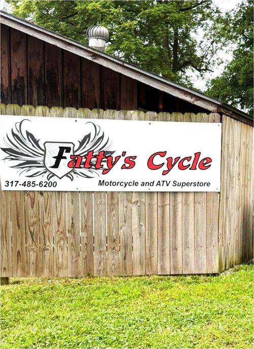Fatty's Cycle motorcycle and ATV service sign on a rustic wooden building with grass in front