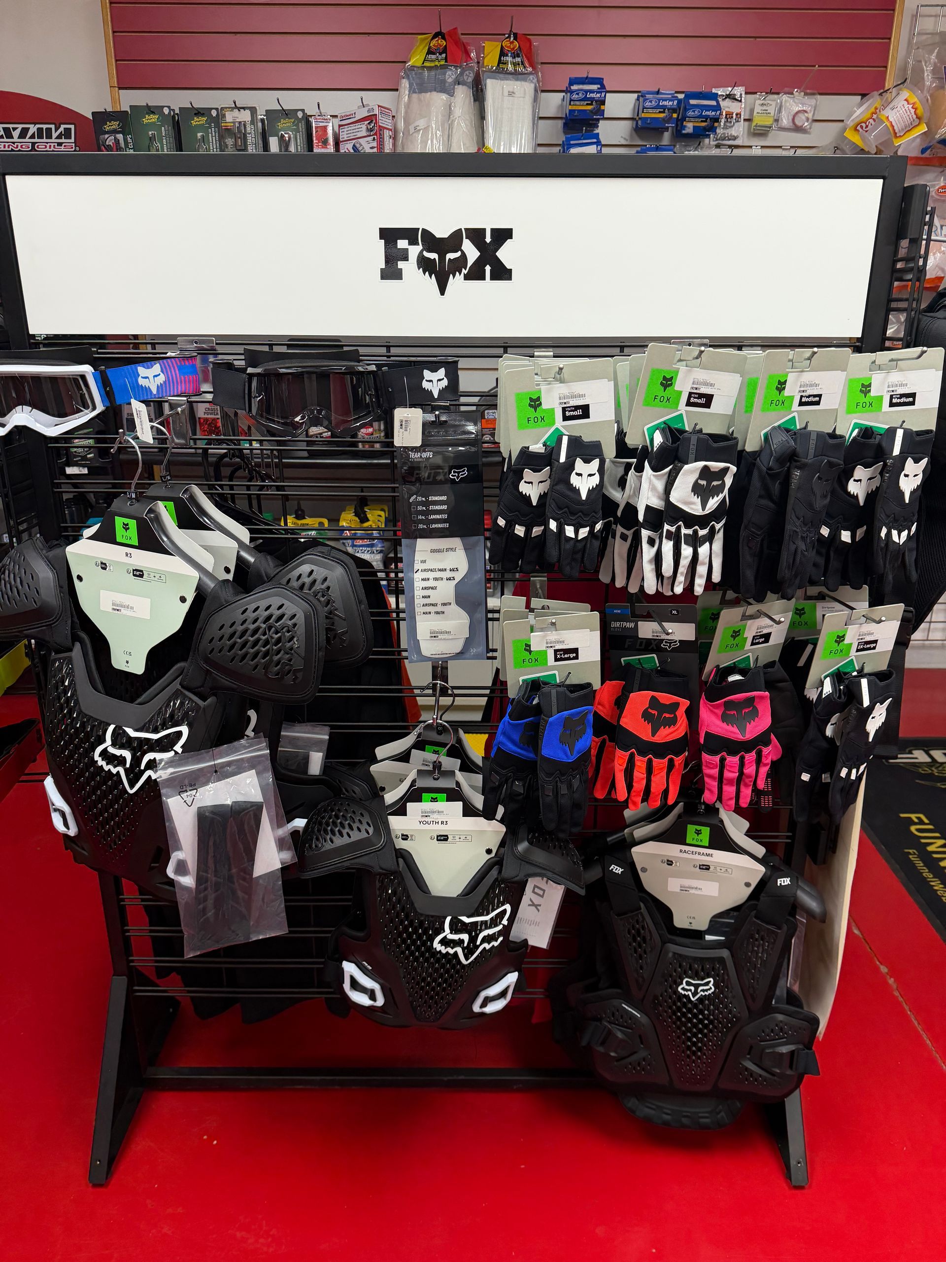 Display of black-and-white motocross gear and accessories on shelves in a store.