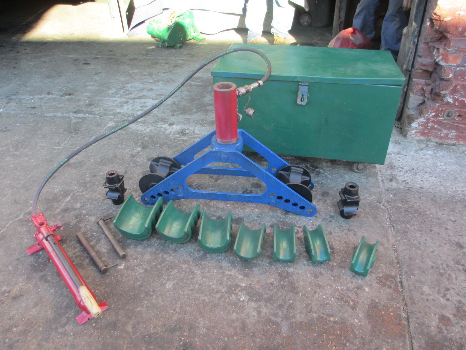 A pipe bending machine is sitting next to a green box