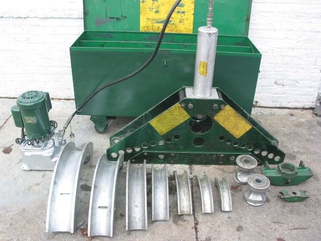 A pipe bending machine is sitting next to a green box