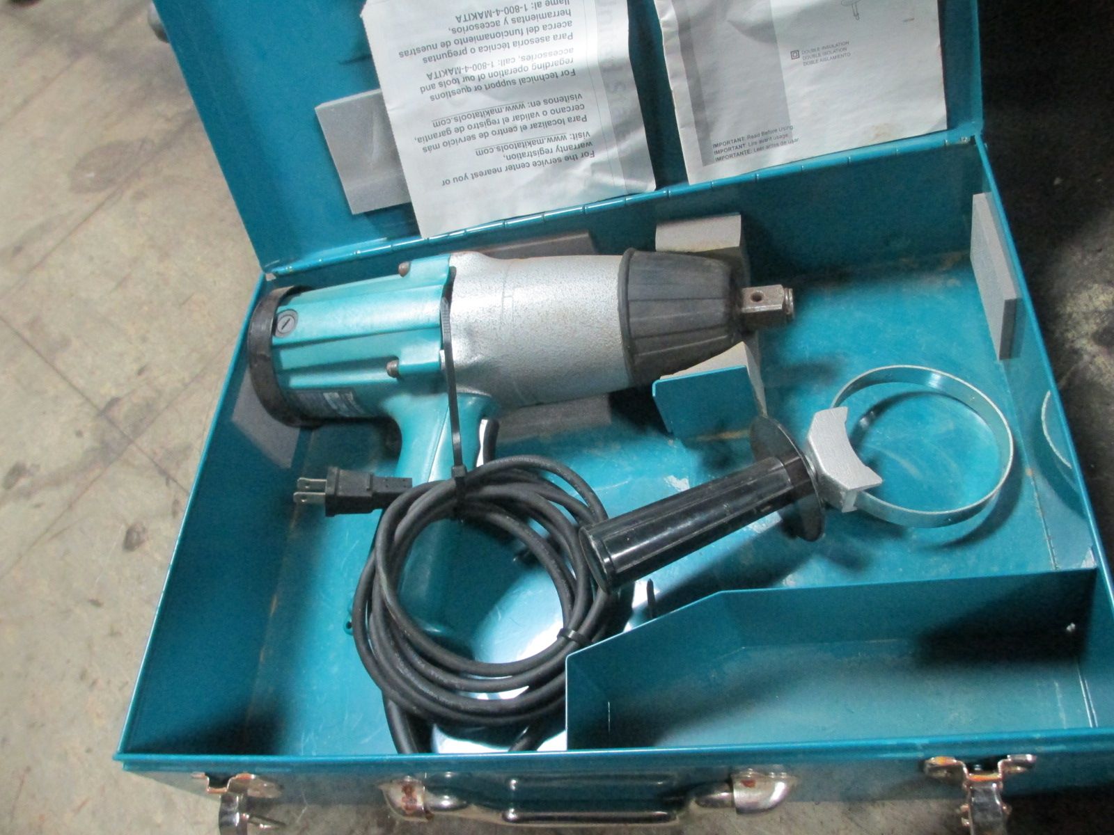 A makita electric wrench is in a blue case