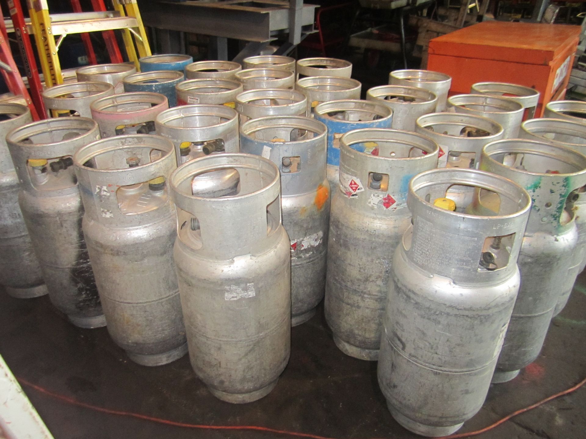A bunch of gas cylinders are lined up on a table