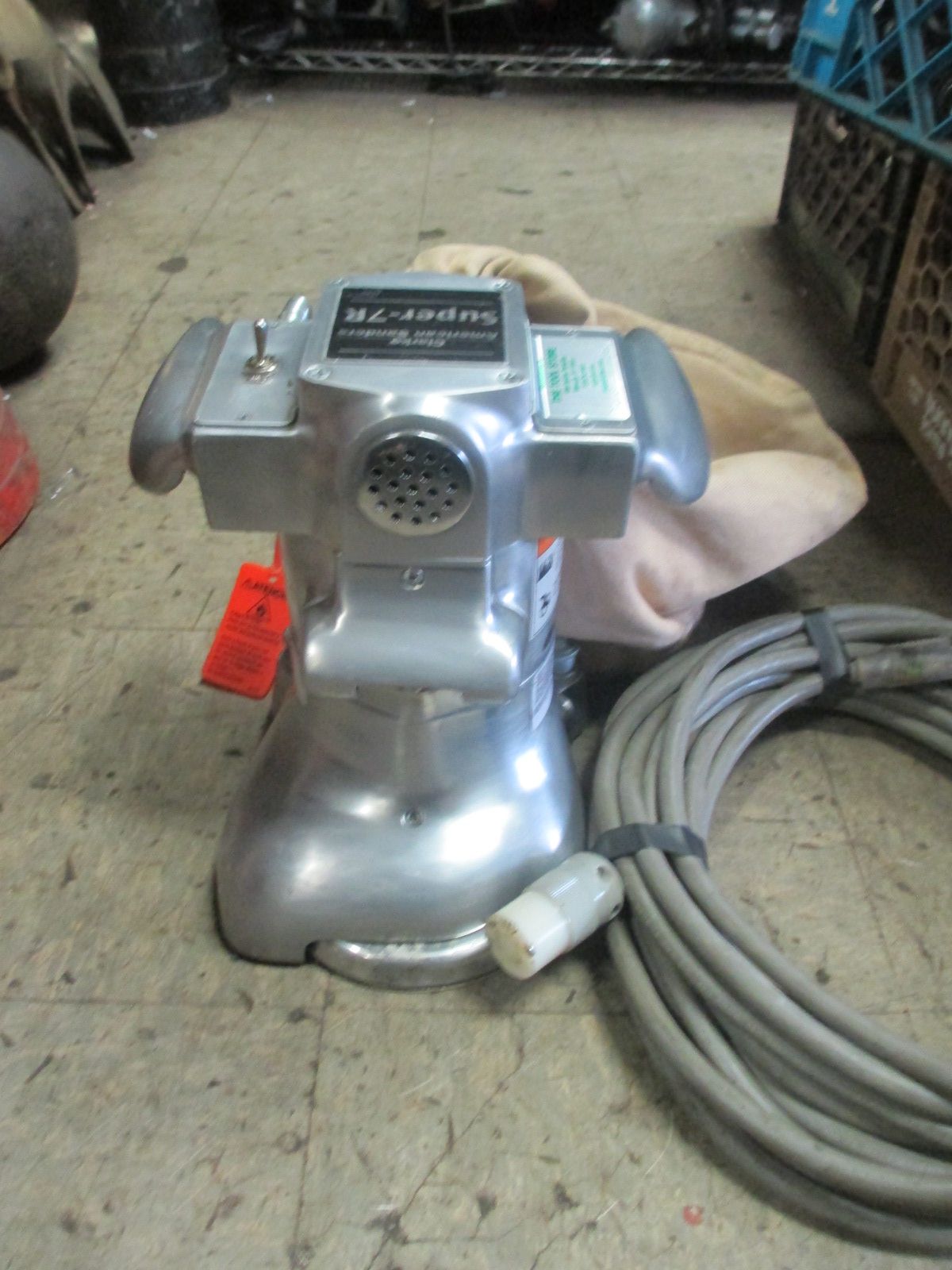 A silver machine with a cord attached to it