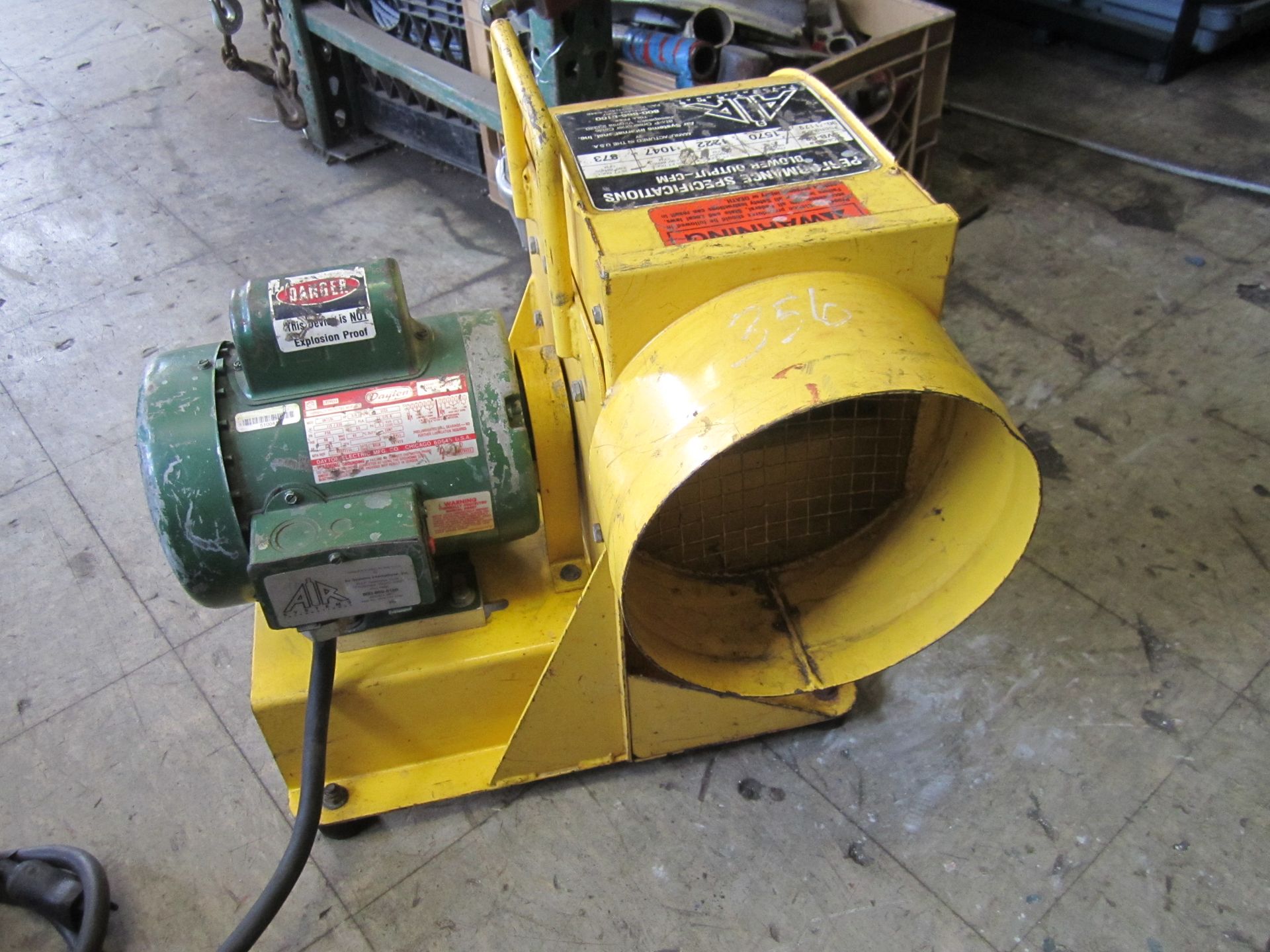 A yellow and green machine with a warning label on it