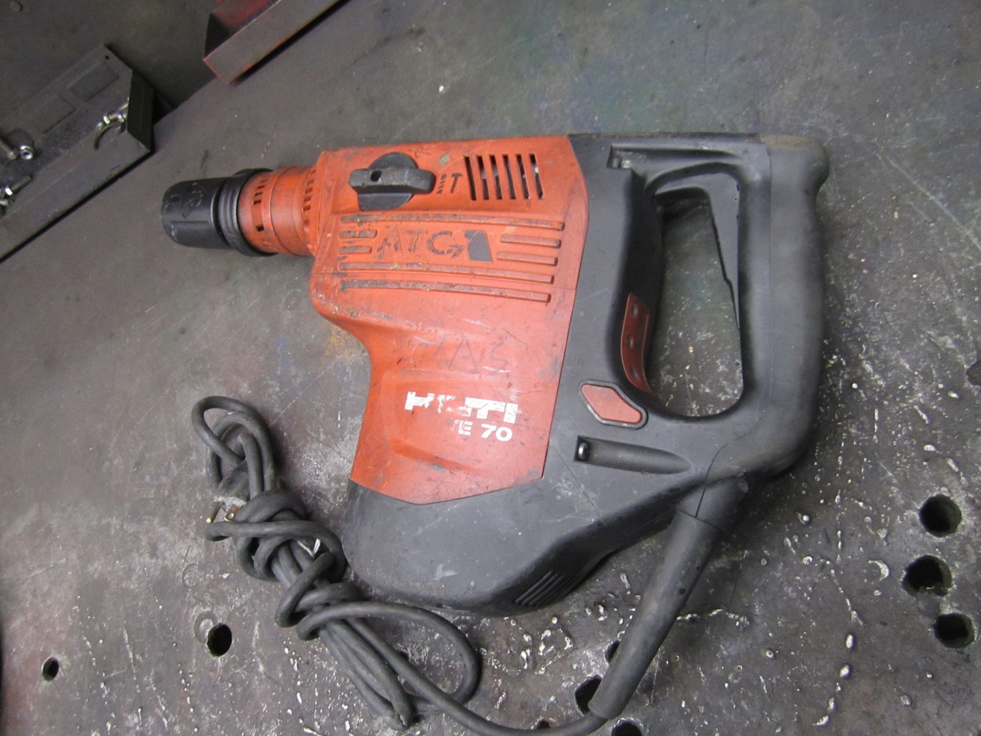 A red and black hammer is sitting on a table