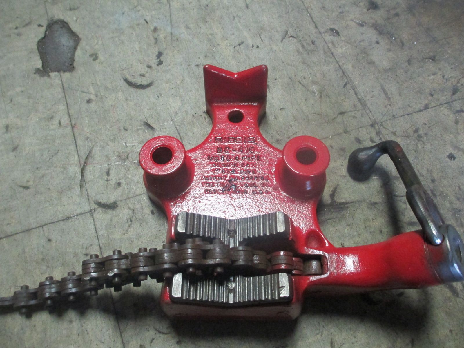 A red tool with a chain attached to it