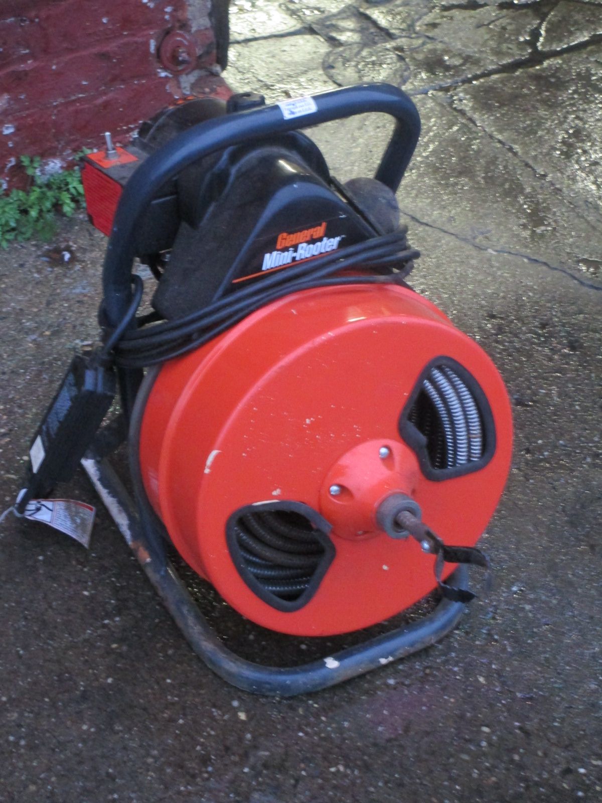 A drain cleaner is sitting on a concrete surface