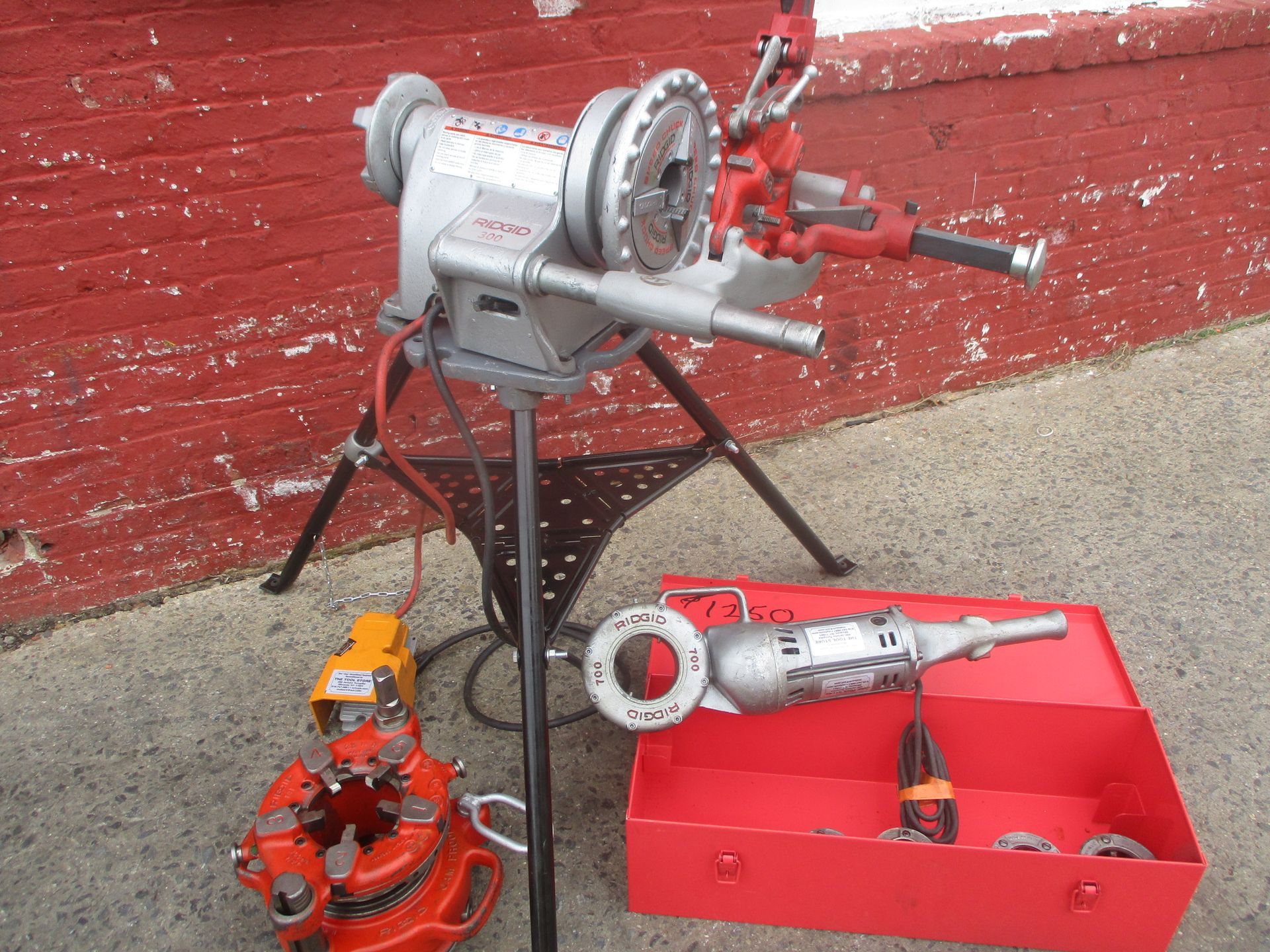 A machine is sitting next to a red box with tools in it