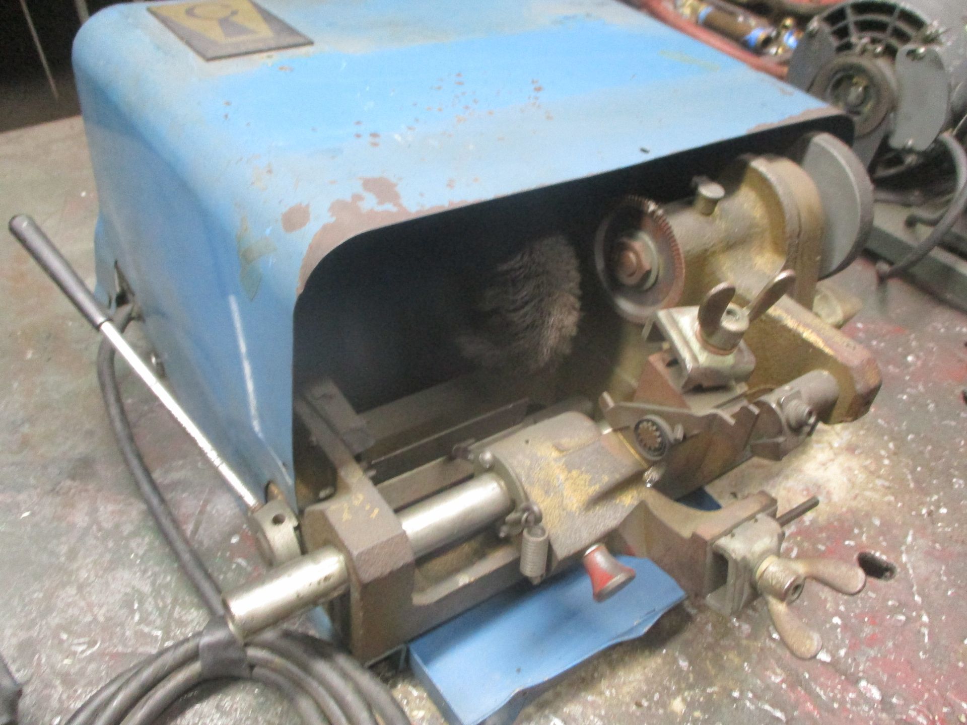 A blue machine with a handle is sitting on a table.