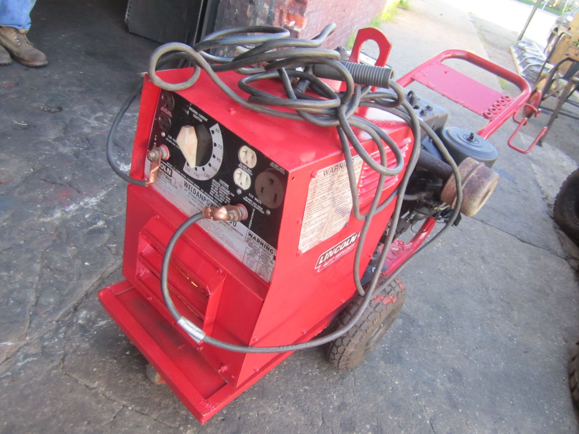 A red welding machine is sitting on the ground