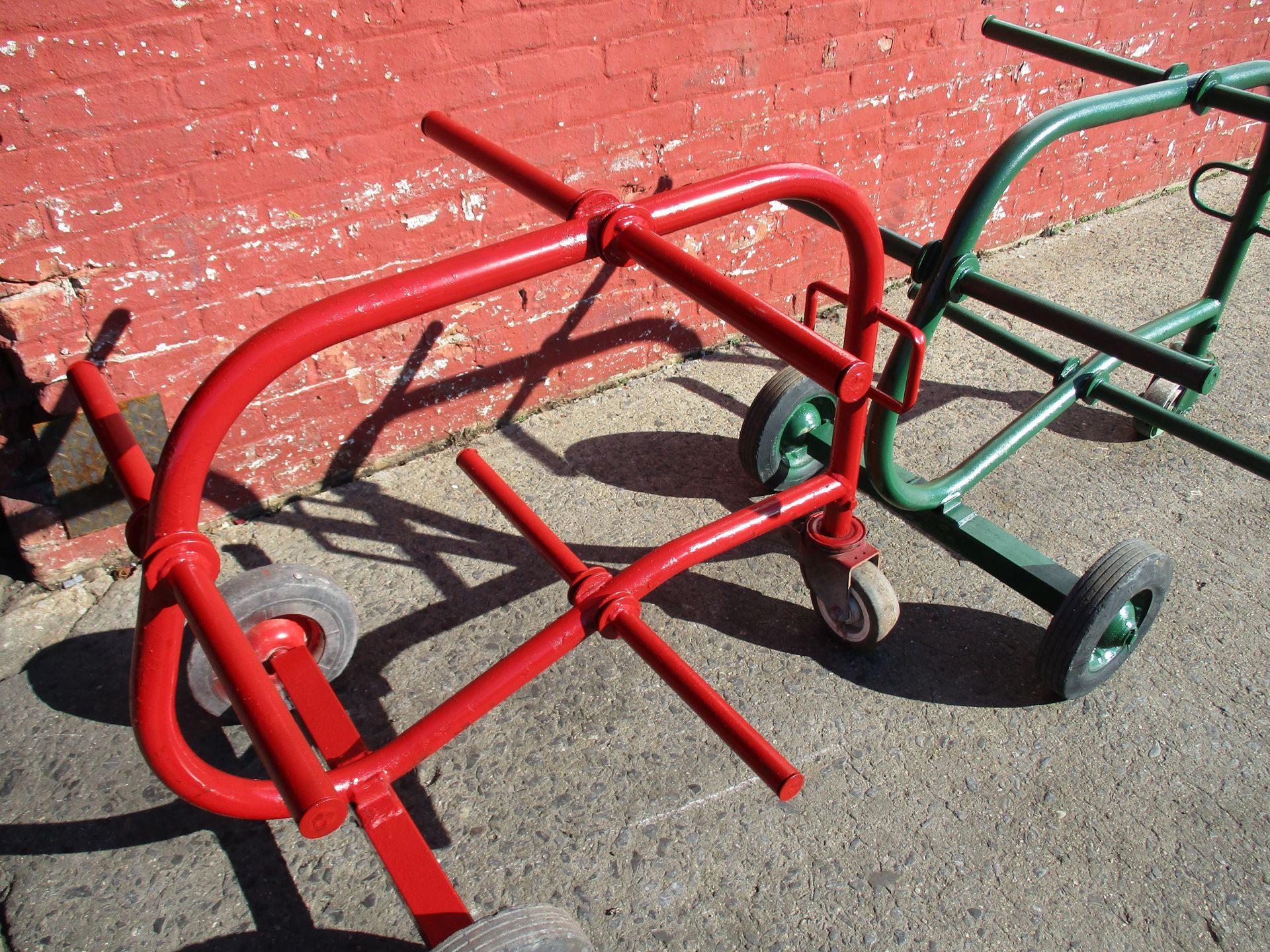 A red cart and a green cart are parked next to each other