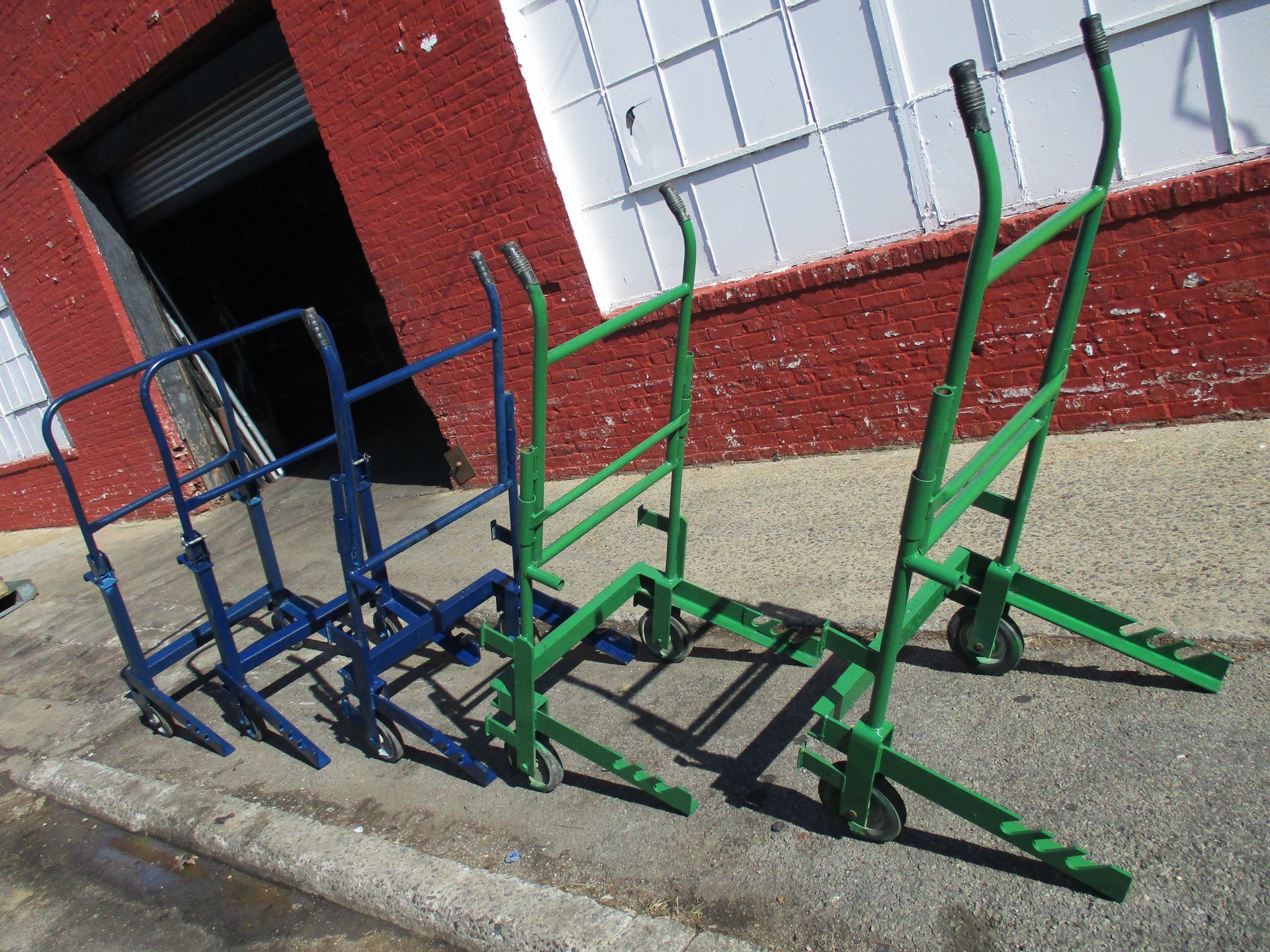 Three carts are lined up on the sidewalk in front of a building