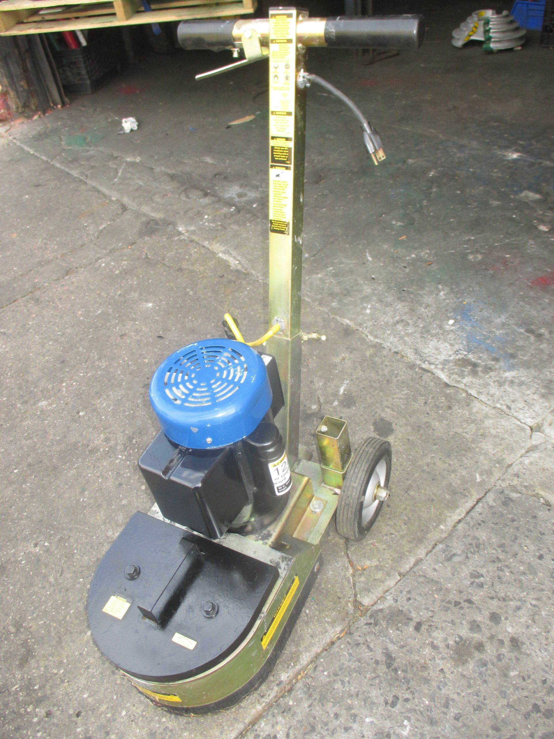 A machine is sitting on the ground in a garage.