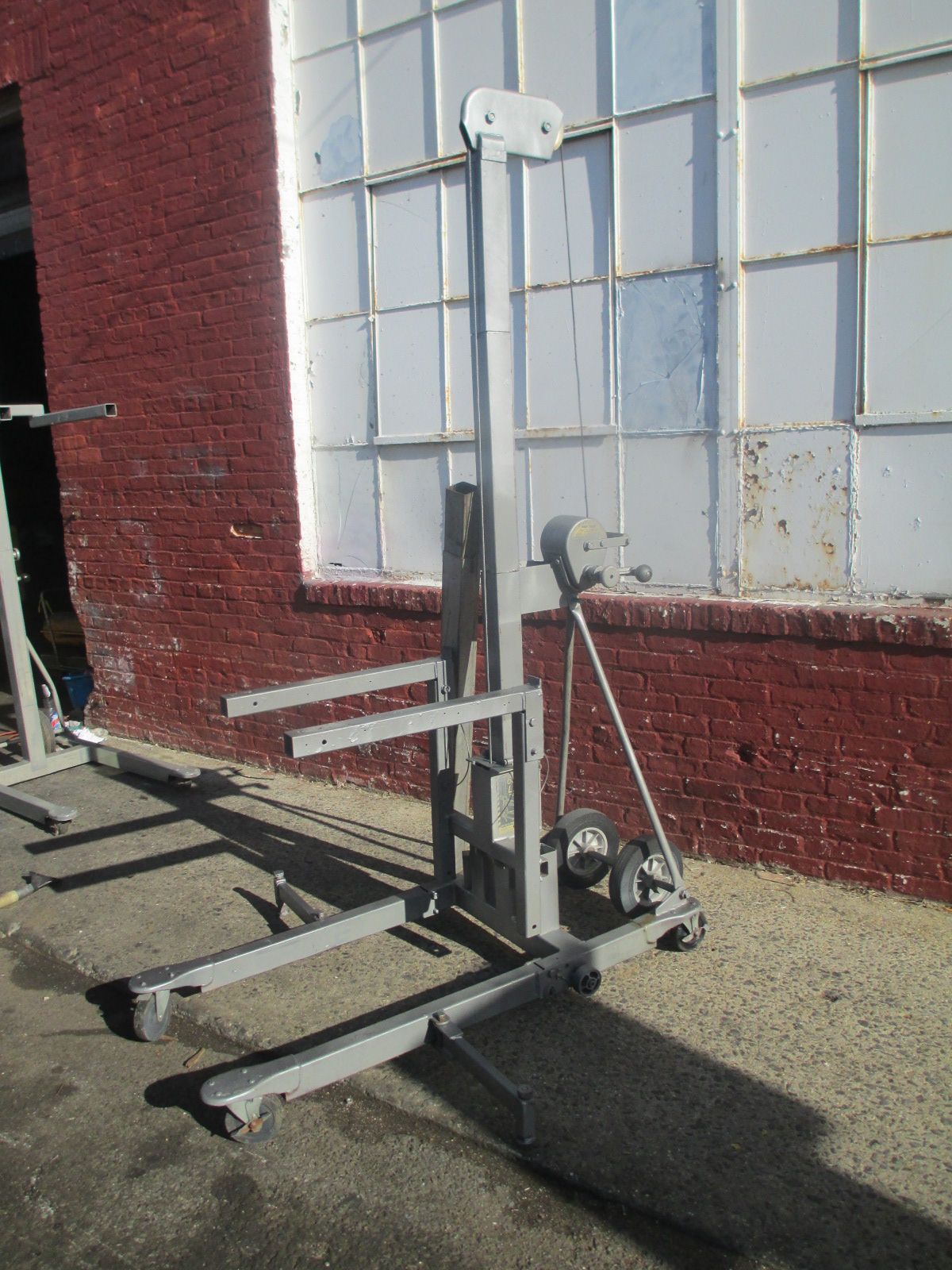 A forklift is parked in front of a brick building