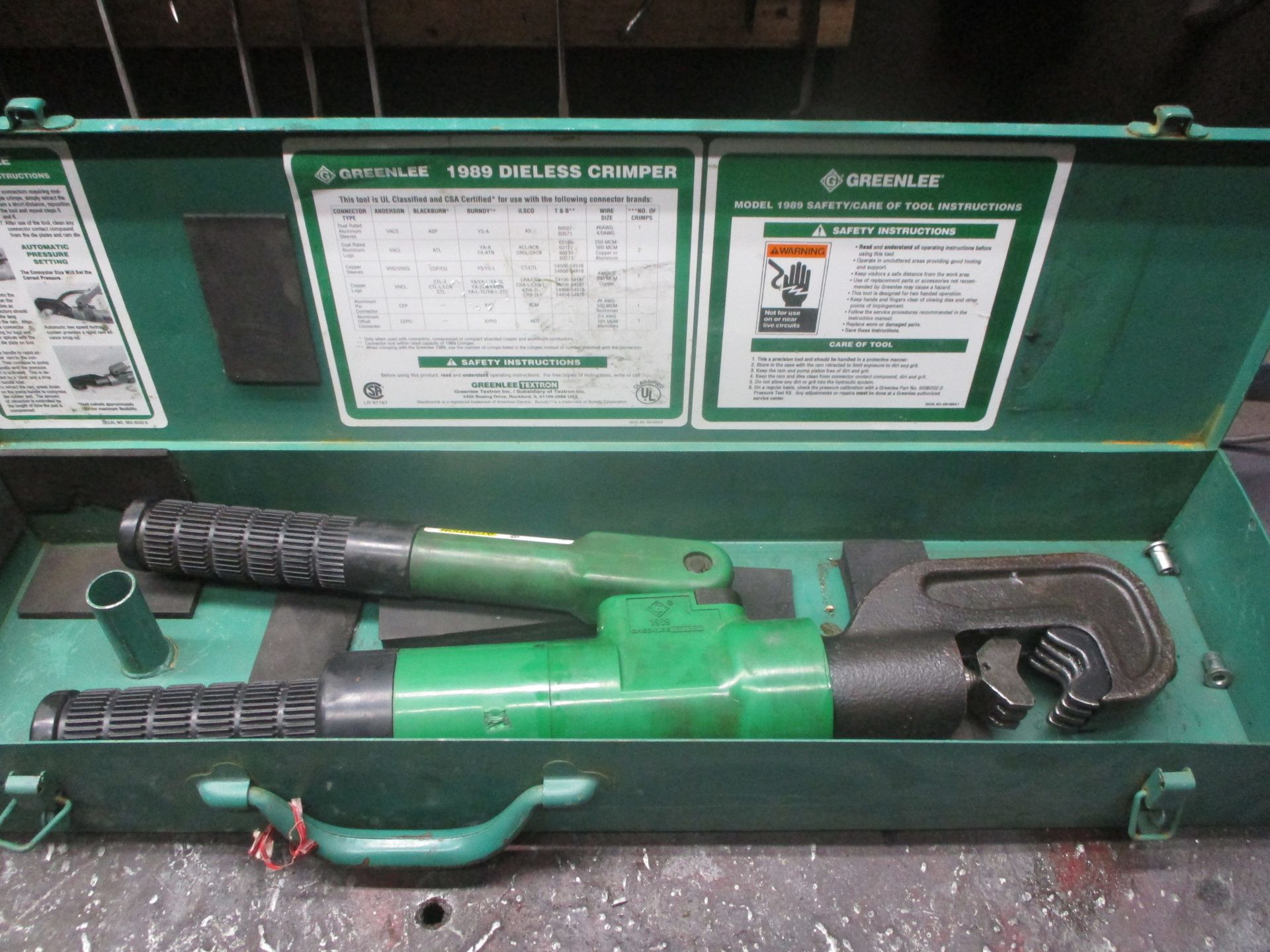 A green tool in a case that says ' hydraulic ' on it