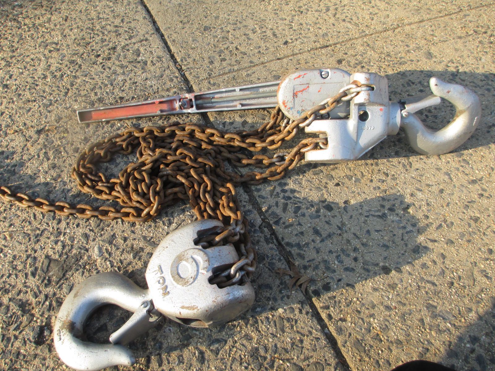 A pair of hooks and chains on a concrete surface