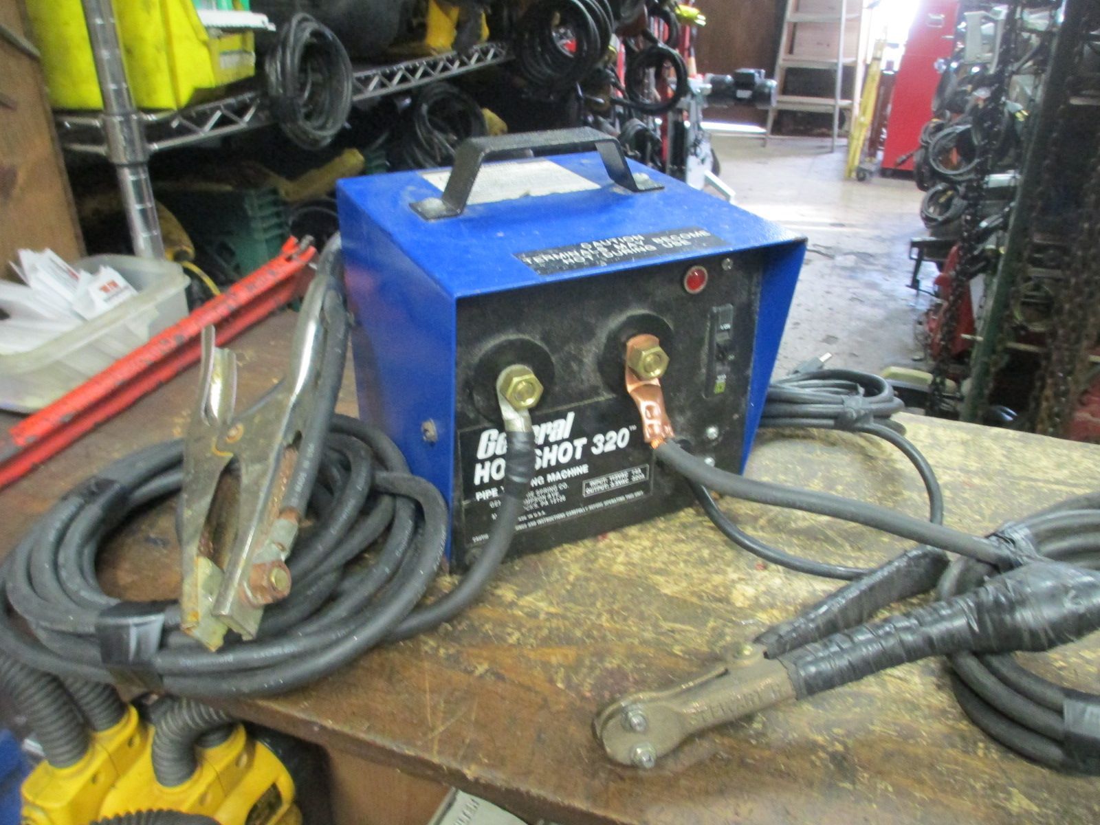 A welding machine is sitting on a wooden table.