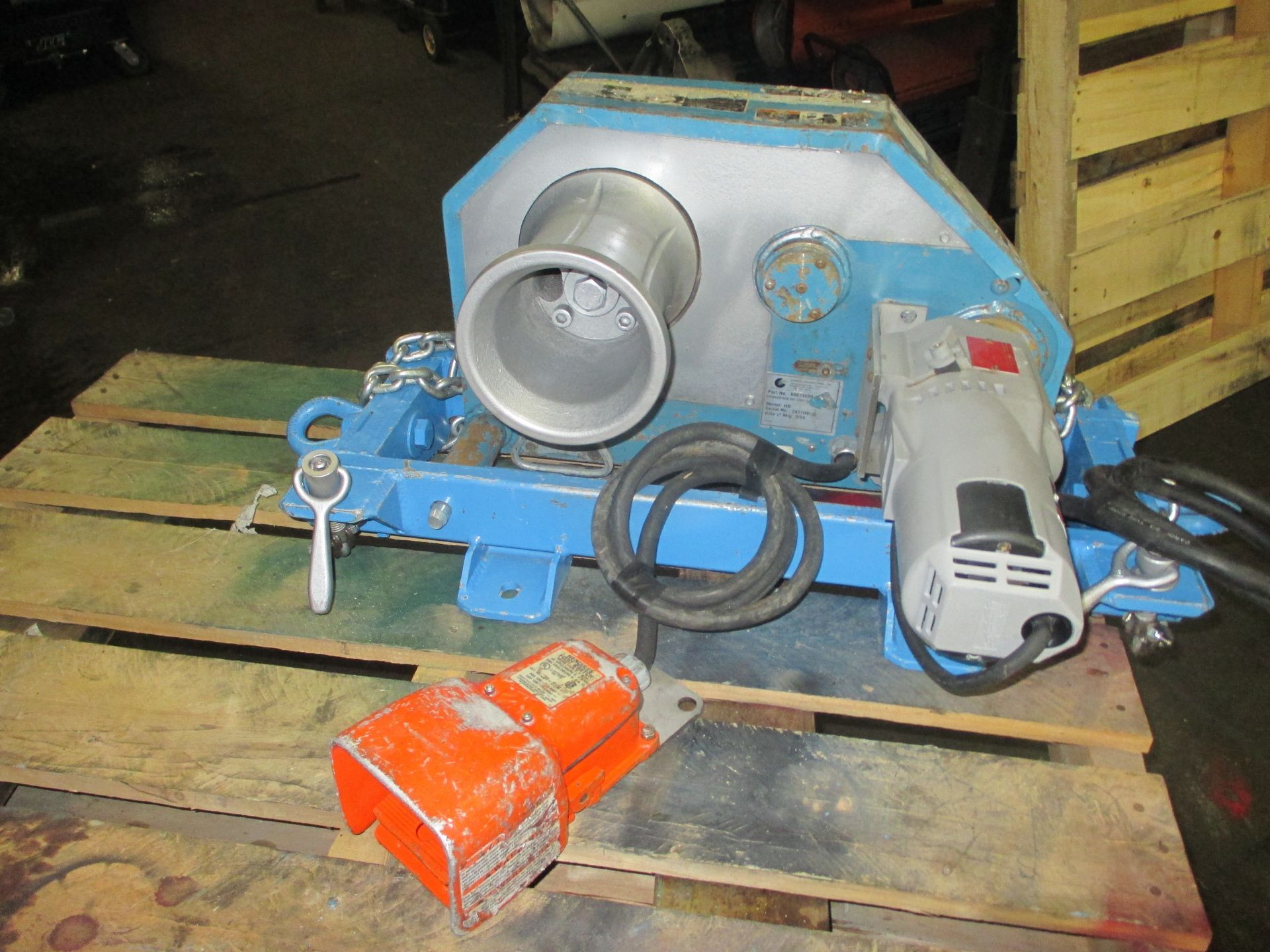 A blue and white machine is sitting on a wooden pallet