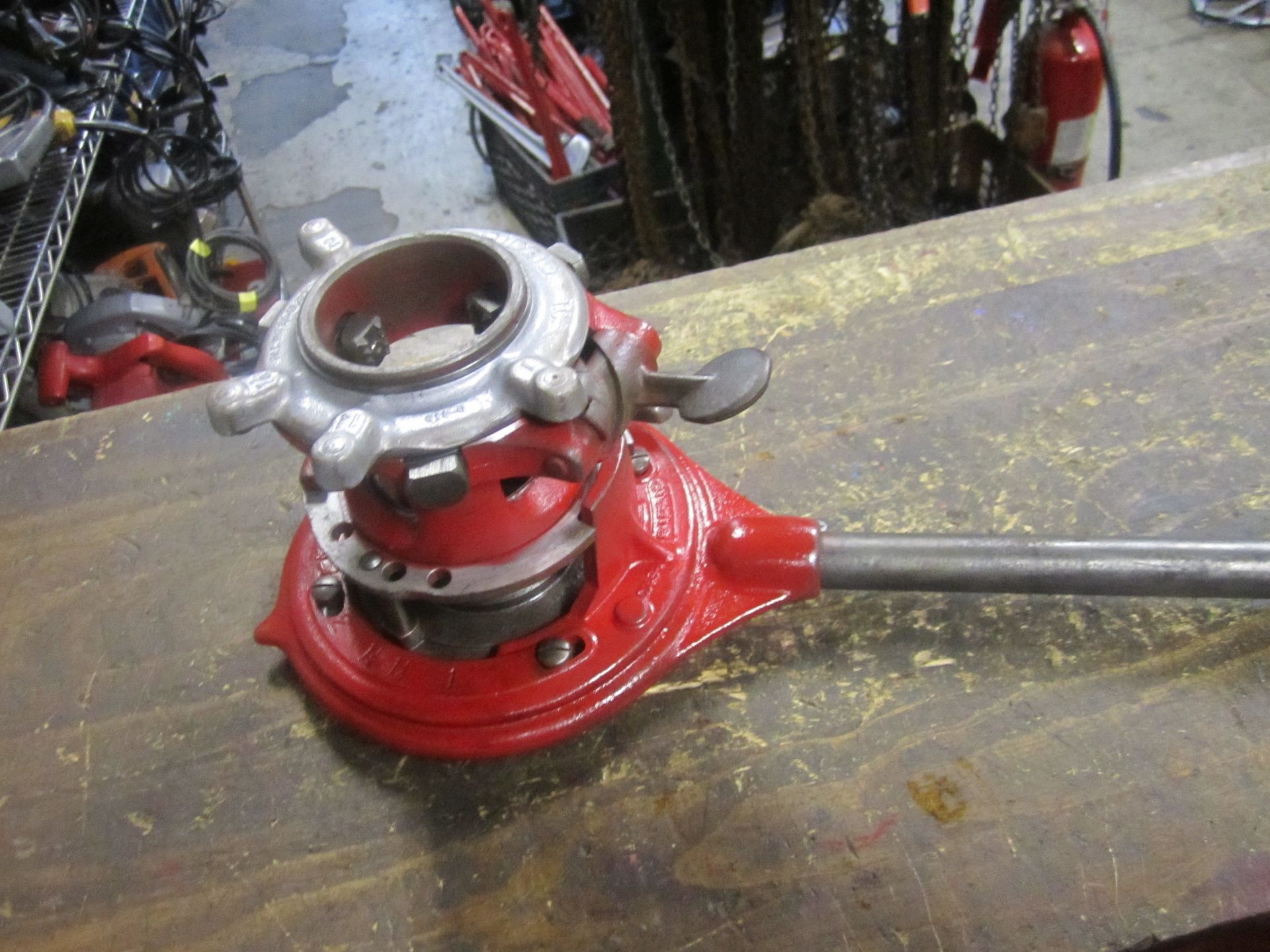 A red tool is sitting on a wooden table
