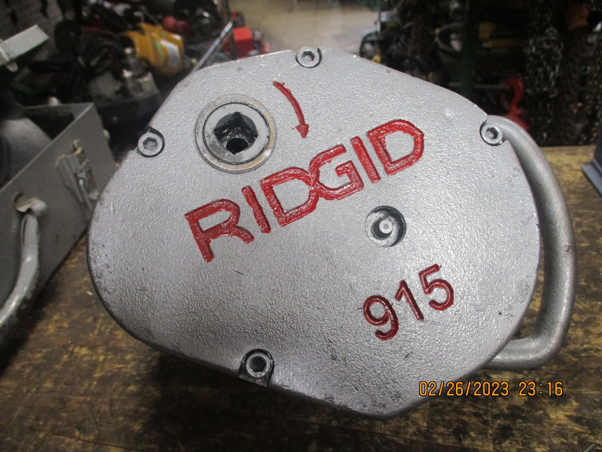 A ridgid 915 machine is sitting on a wooden table.